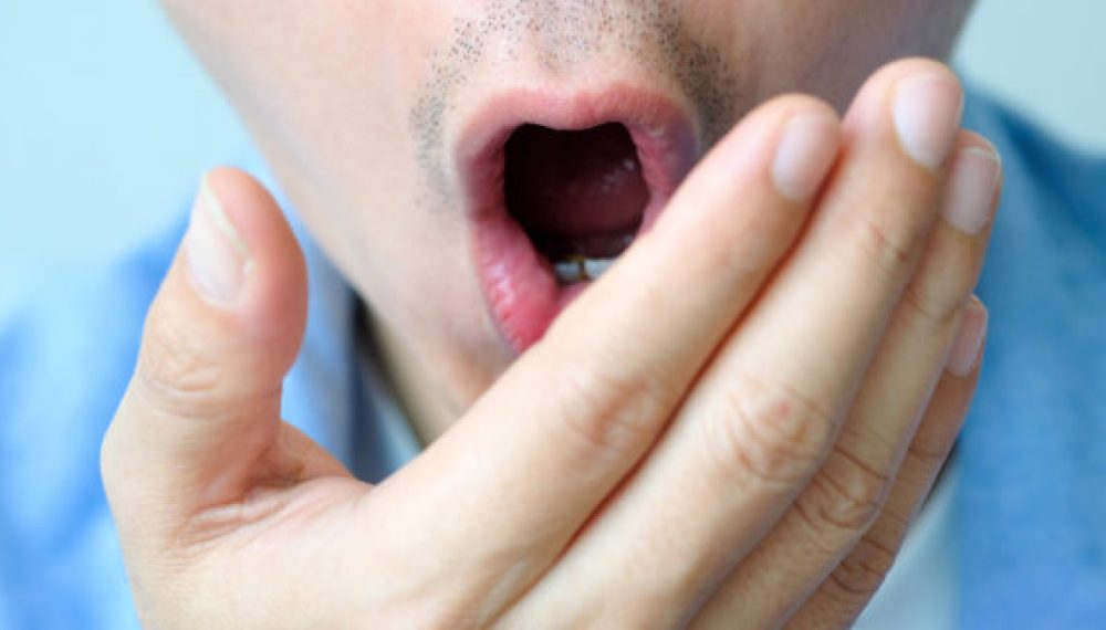 Oral health Men use hands to check for bad breath and breathe. Oral health Men use hands to check for bad breath and breathe.